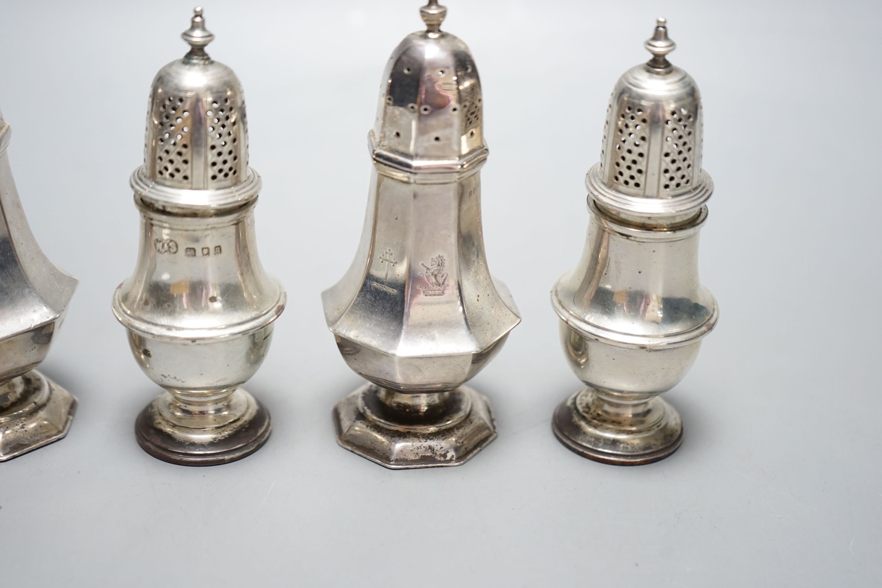 A pair of late Victorian silver panelled pepperettes, London, 1900 and a later pair, London, 1931, 232 grams.